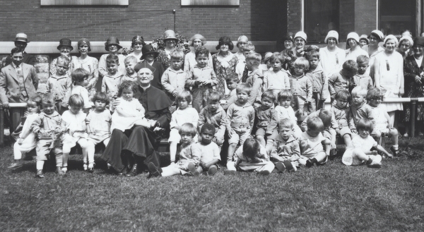 Father Baker outside with some children.
